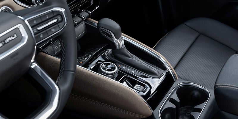 Close-up of a car's gear shift, showcasing the design and layout of the gear lever and surrounding controls.